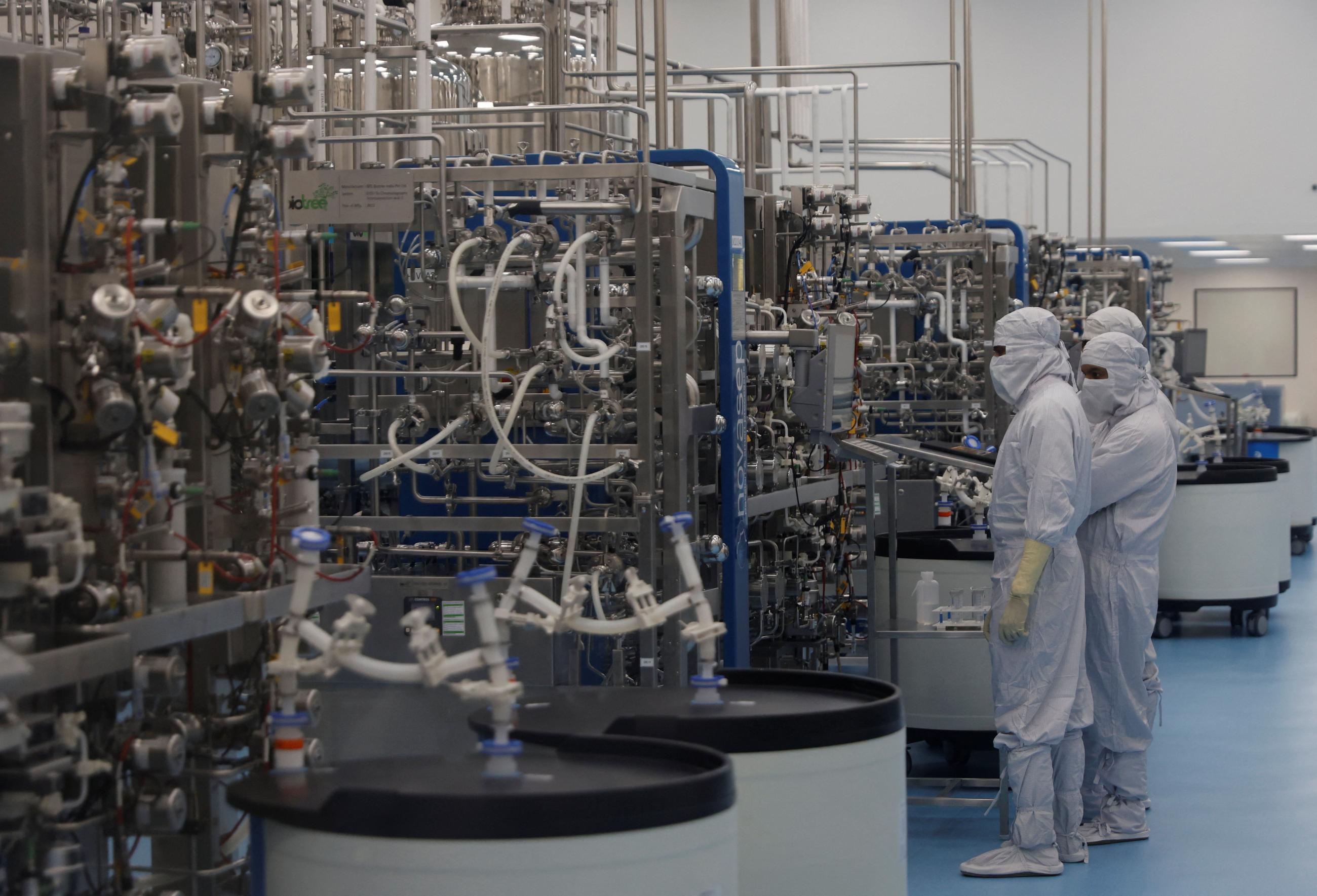 Employees in personal protective equipment work inside a lab where the HPV vaccine is produced at Serum Institute of India, in Pune, India, on February 27, 2024. 